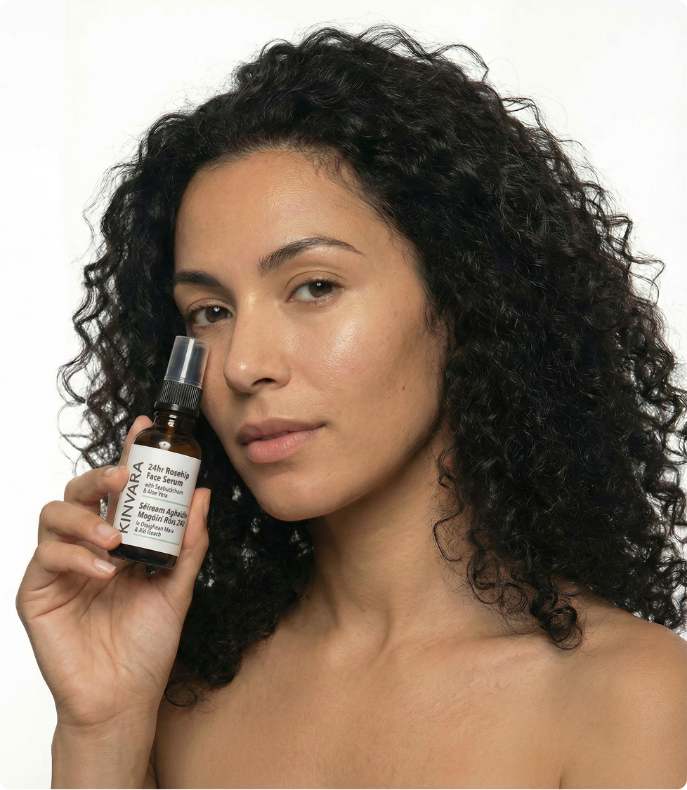 Woman holding the Kinvara 24hr Rosehip Face Serum to her cheek